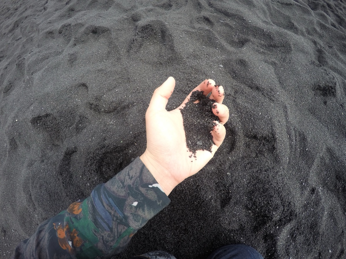 A handful of black volcanic sand
