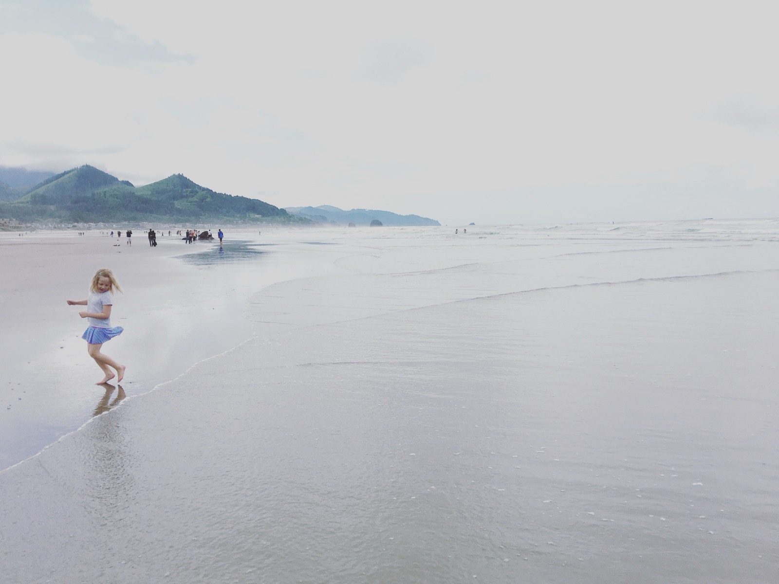 A child running along a misty Oregon coast shoreline