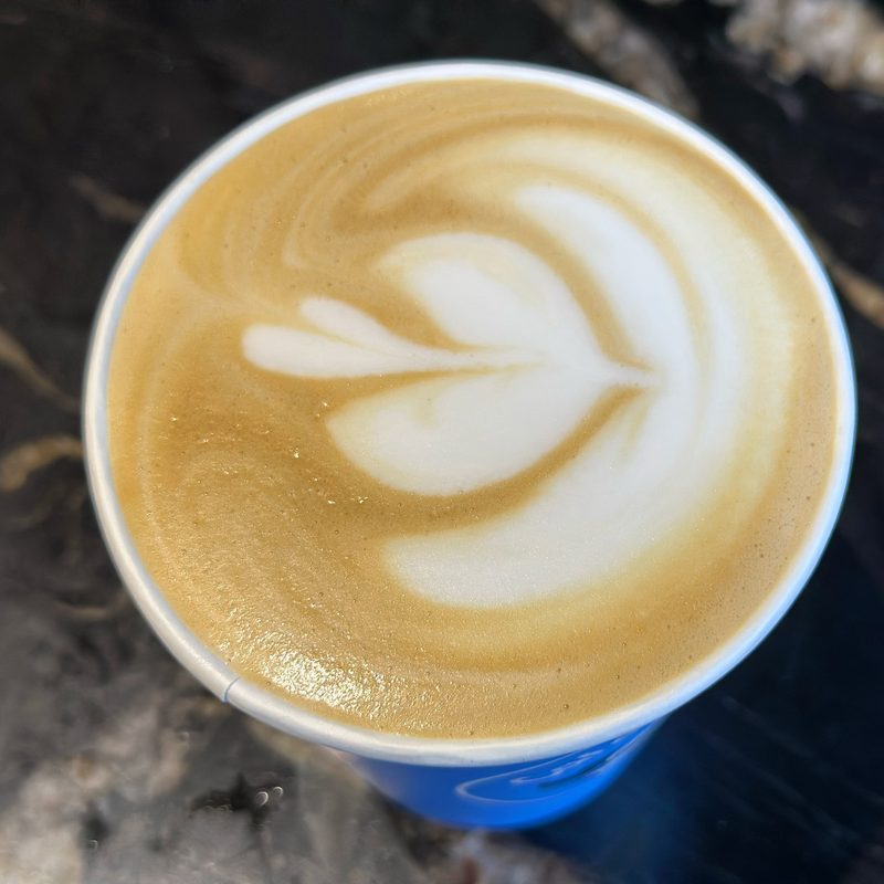 Heart latte art in a blue cup on black veined marble