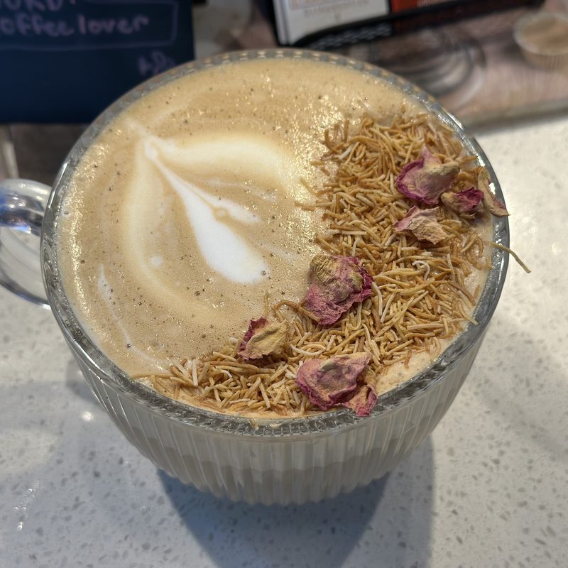 Latte in front of a caf&eacute; chalkboard menu