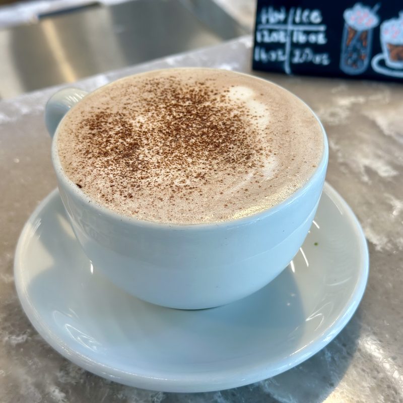 Cappuccino dusted with cocoa in a white cup and saucer