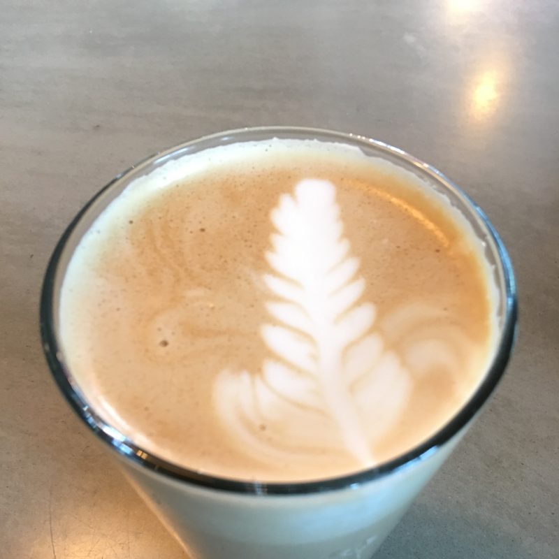 Rosetta latte in a clear glass on grey concrete