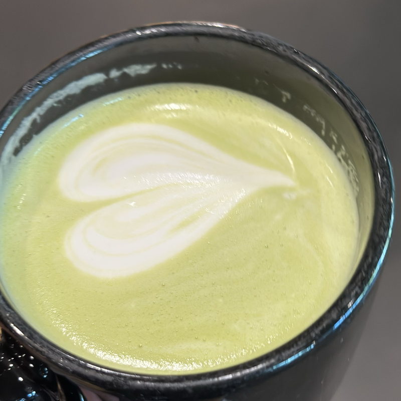 Matcha latte with a heart in a black mug