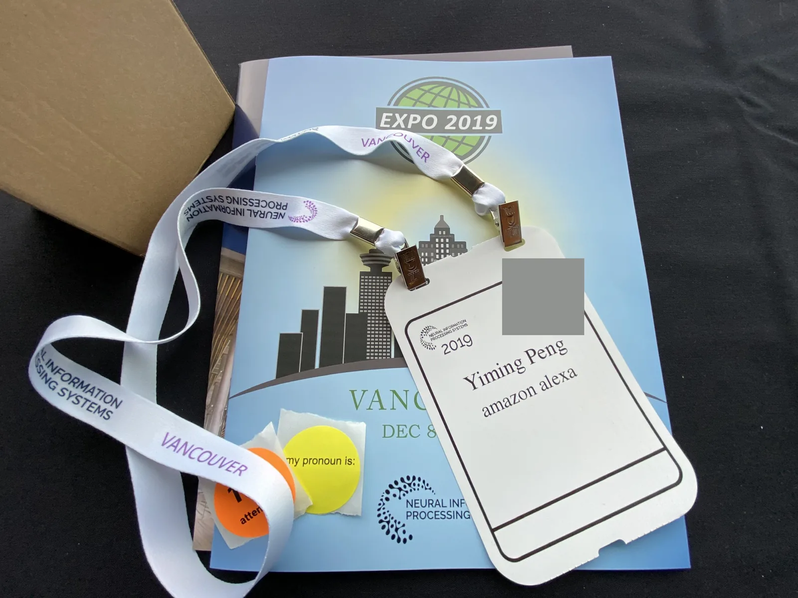The NeurIPS 2019 badge, lanyard and programme on the first morning, the badge's QR code blanked.